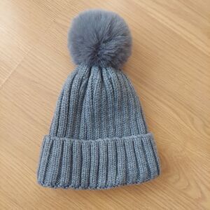 Women's grey ribbed knit beanie with faux fur pom-pom